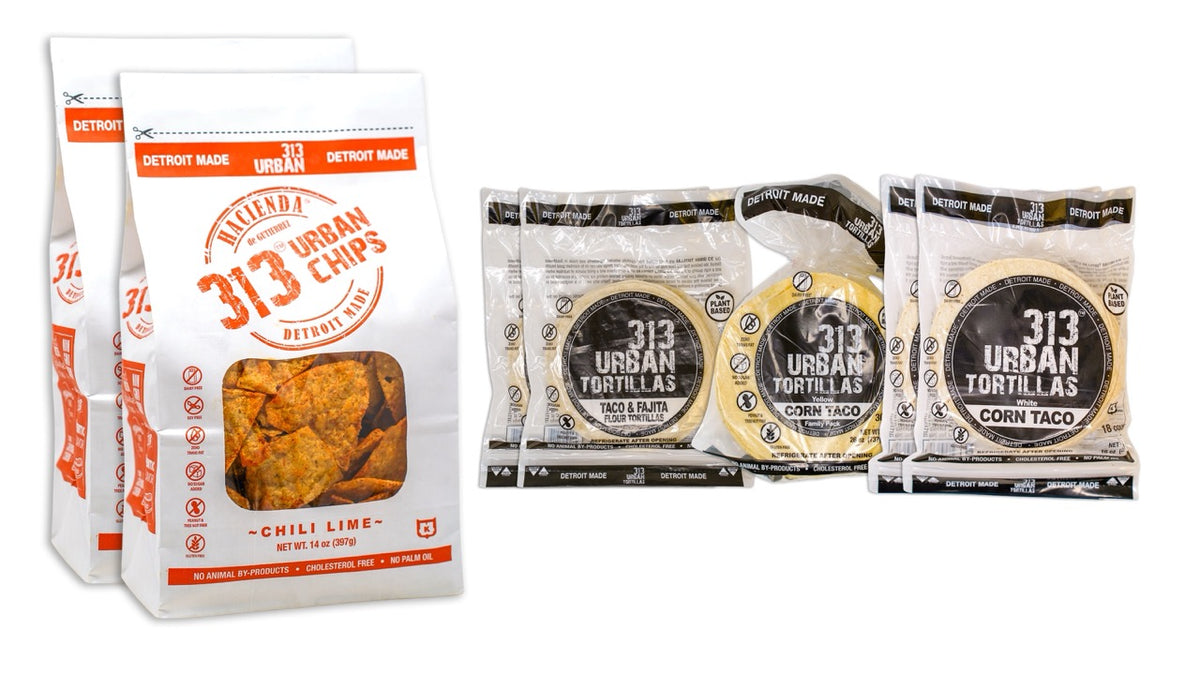Image: A display featuring two bags of 313 Urban Chili Lime tortilla chips on the left. To the right, there are two bags of 313 Urban 6" Flour Tortillas, one bag of 313 Urban Yellow Corn Tortillas, and two bags of 313 Urban White Corn Tortillas, all labeled "Detroit Made."