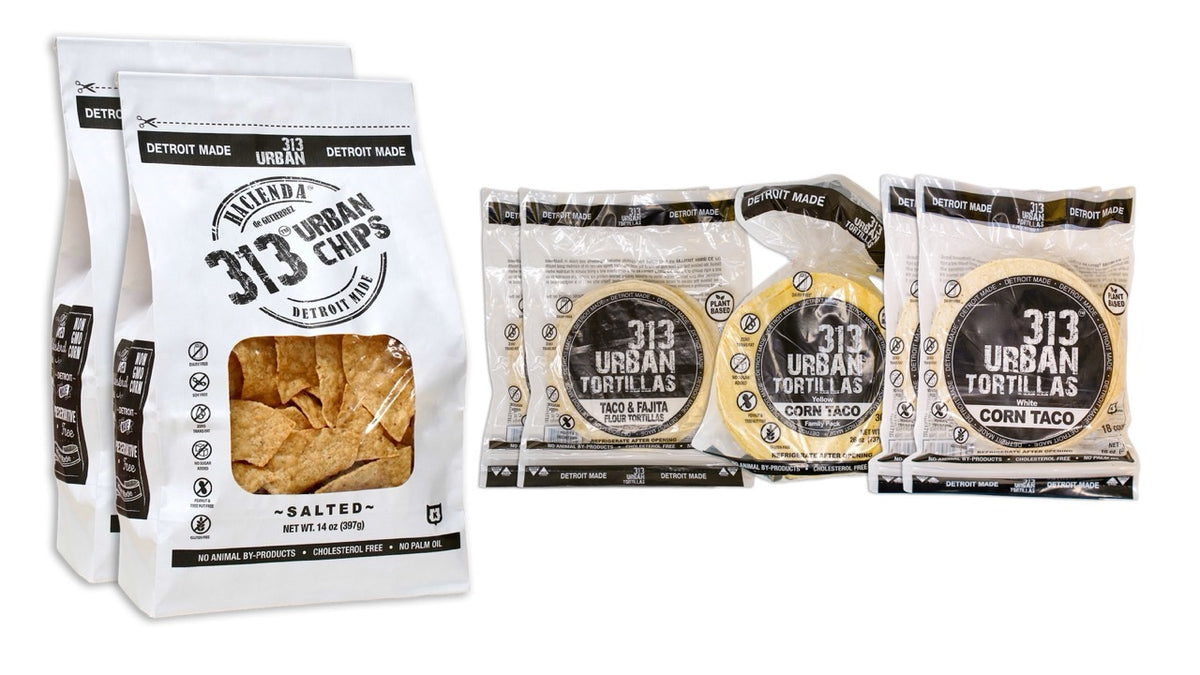 Image: A display featuring two bags of 313 Urban Salted tortilla chips on the left. To the right, there are two bags of 313 Urban 6" Flour Tortillas, one bag of 313 Urban Yellow Corn Tortillas, and two bags of 313 Urban White Corn Tortillas, all labeled "Detroit Made."