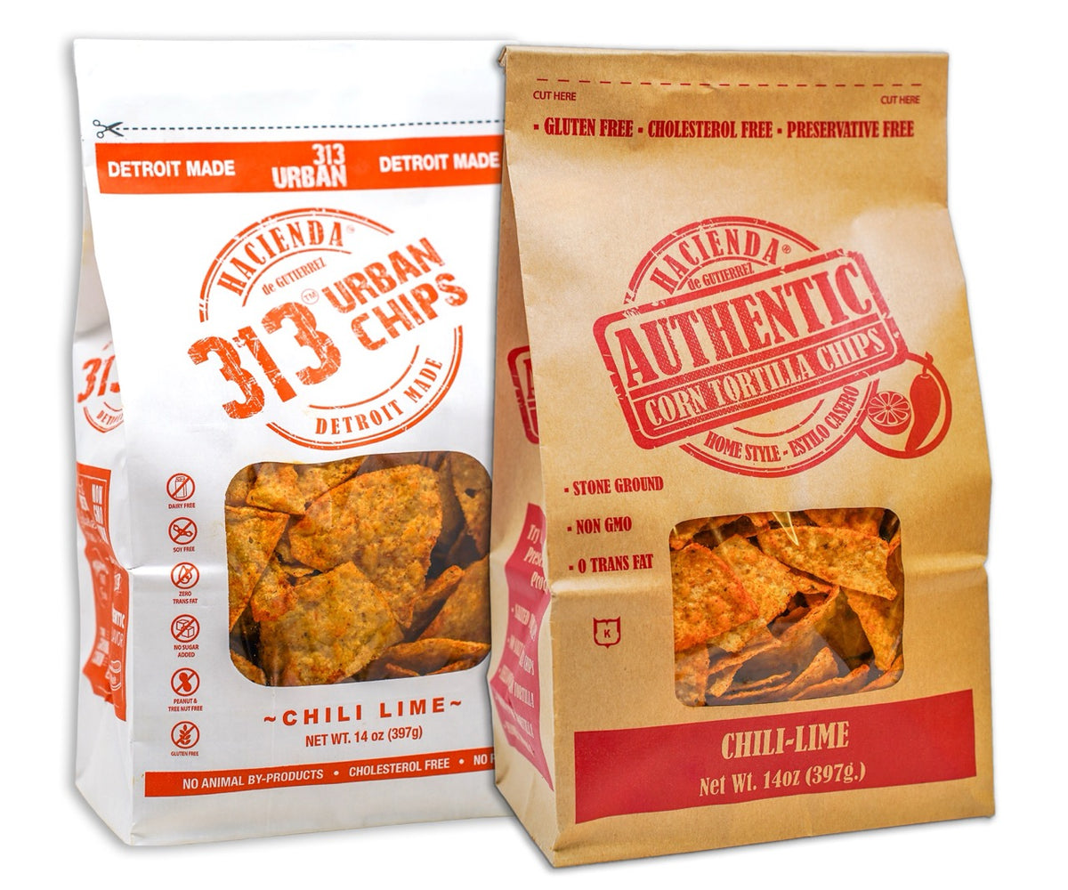 A bag of Hacienda Authentic Corn Tortilla Chips labeled "Chili Lime" next to a bag of 313 Urban Chili Lime chips, both featuring clear windows to showcase the chips inside, and emphasizing that they are "Detroit Made."