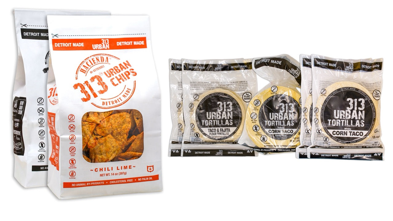 Image: A display featuring one bag of 313 Urban Salted tortilla chips alongside one bag of 313 Urban Chili Lime tortilla chips on the left. To the right, there are two bags of 313 Urban 6" Flour Tortillas, one bag of 313 Urban Yellow Corn Tortillas, and two bags of 313 Urban White Corn Tortillas, all labeled "Detroit Made."