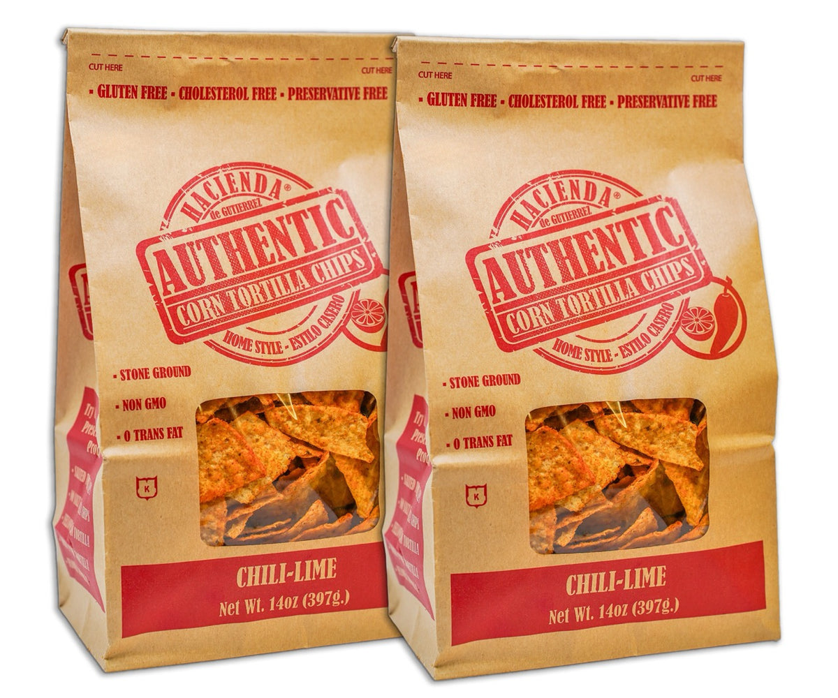 Two bags of Hacienda Authentic Corn Tortilla Chips labeled &quot;Chili Lime,&quot; showcasing the chips through the transparent window, with branding emphasizing they are &quot;Home Style&quot; and &quot;Detroit Made.&quot;